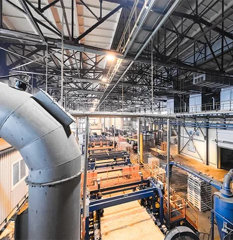 Interior de uma fábrica com tubulações e linha de produção
