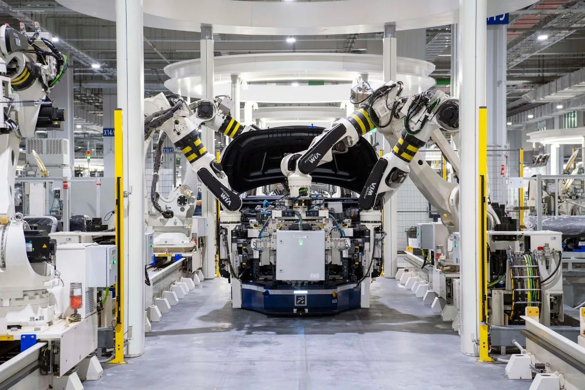 Robôs industriais montando a carroceria de um carro numa linha de montagem automotiva